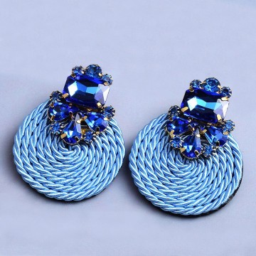 Rhinestone earrings on blue satin